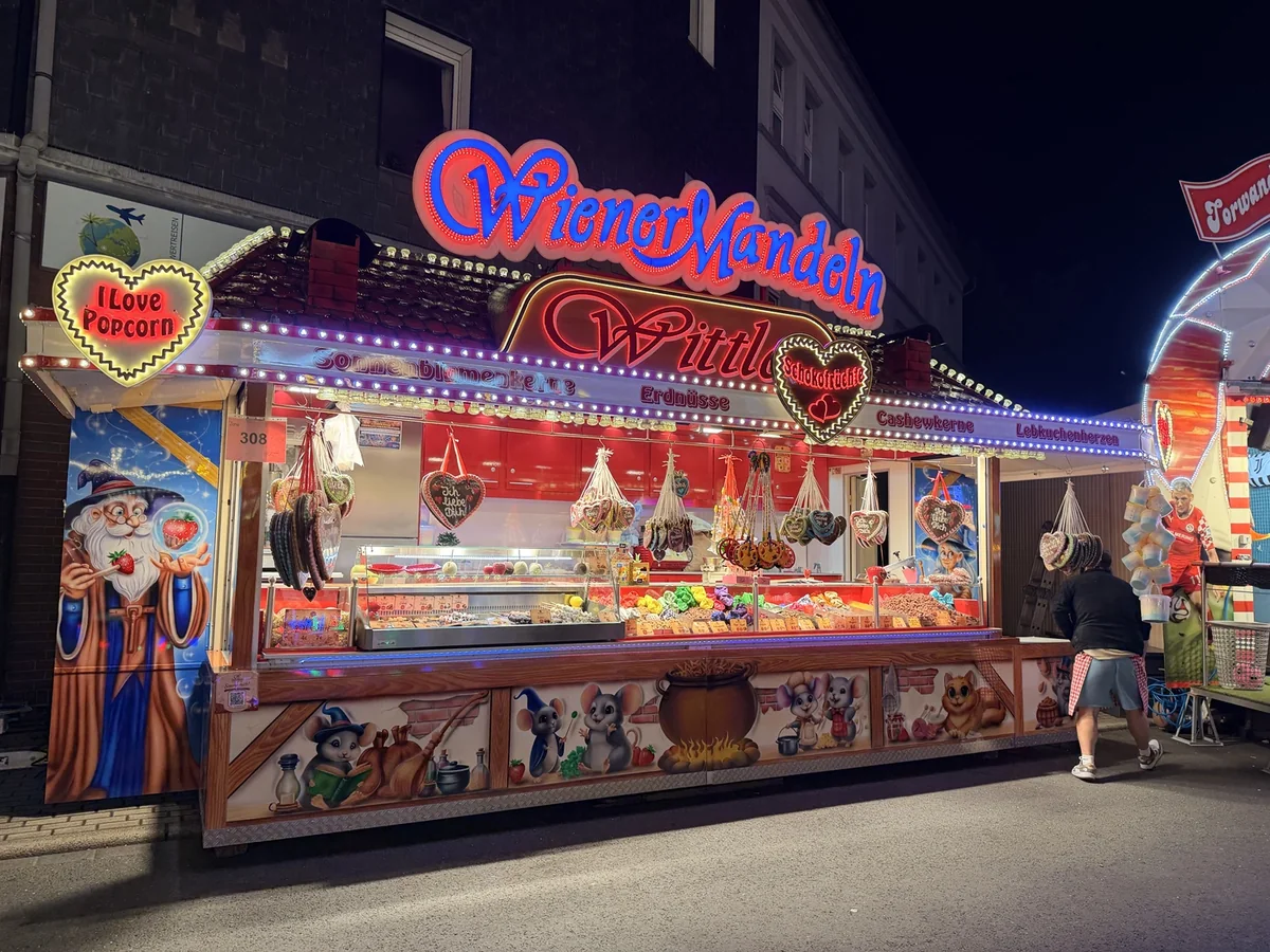 Der beleuchtete Verkaufsstand von Wittlers Wiener Mandeln bei Nacht
